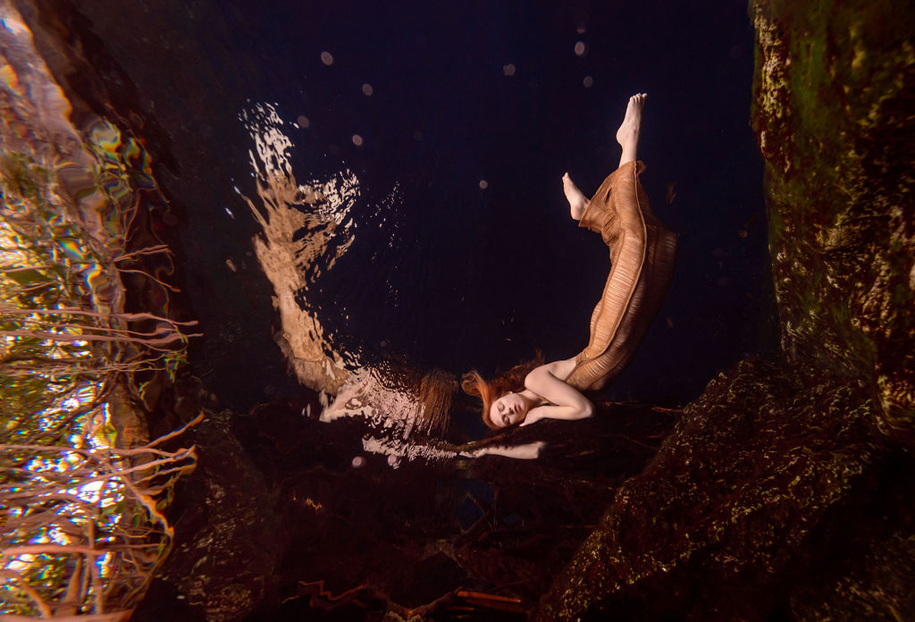 Underwater portrait of a model in a flowing gown photographed in a Florida spring cavern