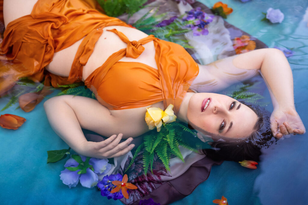 Model in orange dress in shallow water during a private mentoring shoot