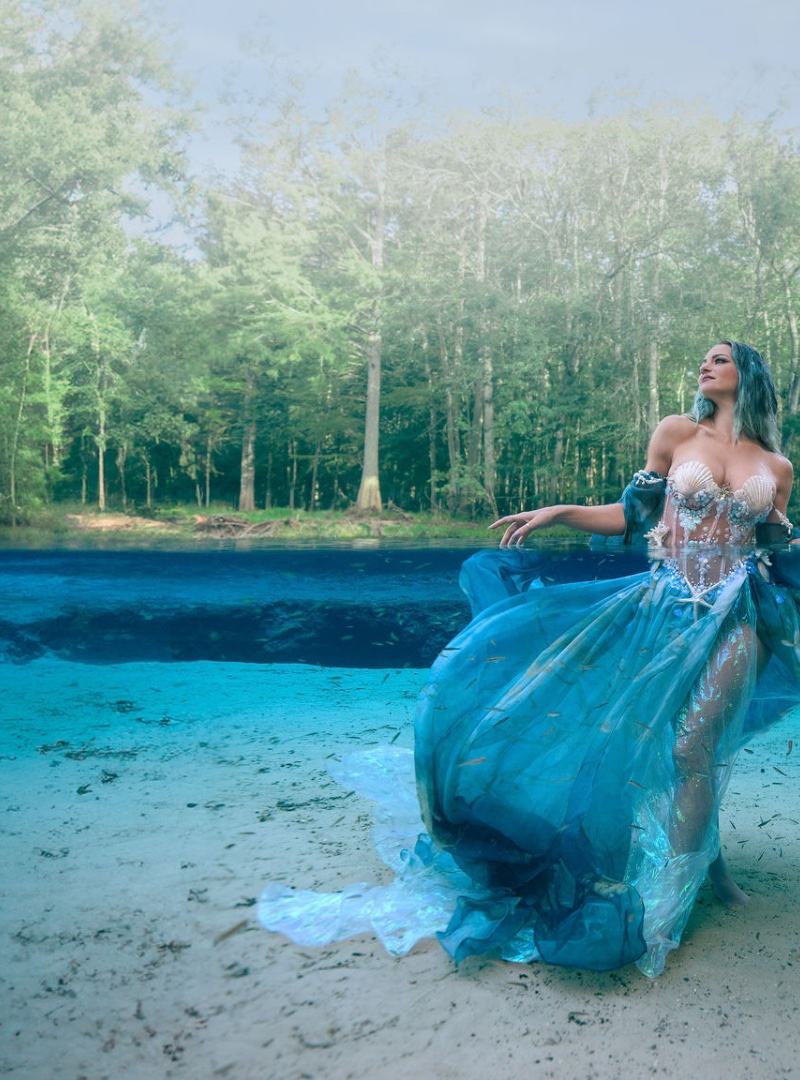 Expecting mother underwater in a flowing teal gown at a Florida spring