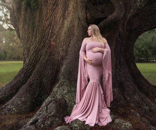 Maternity photoshoot in a dusty pink chiffon gown beneath a Florida oak tree
