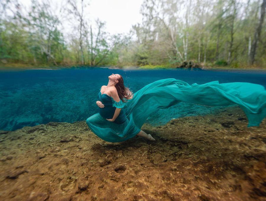 Model in a flowing teal gown photographed underwater in a Florida spring