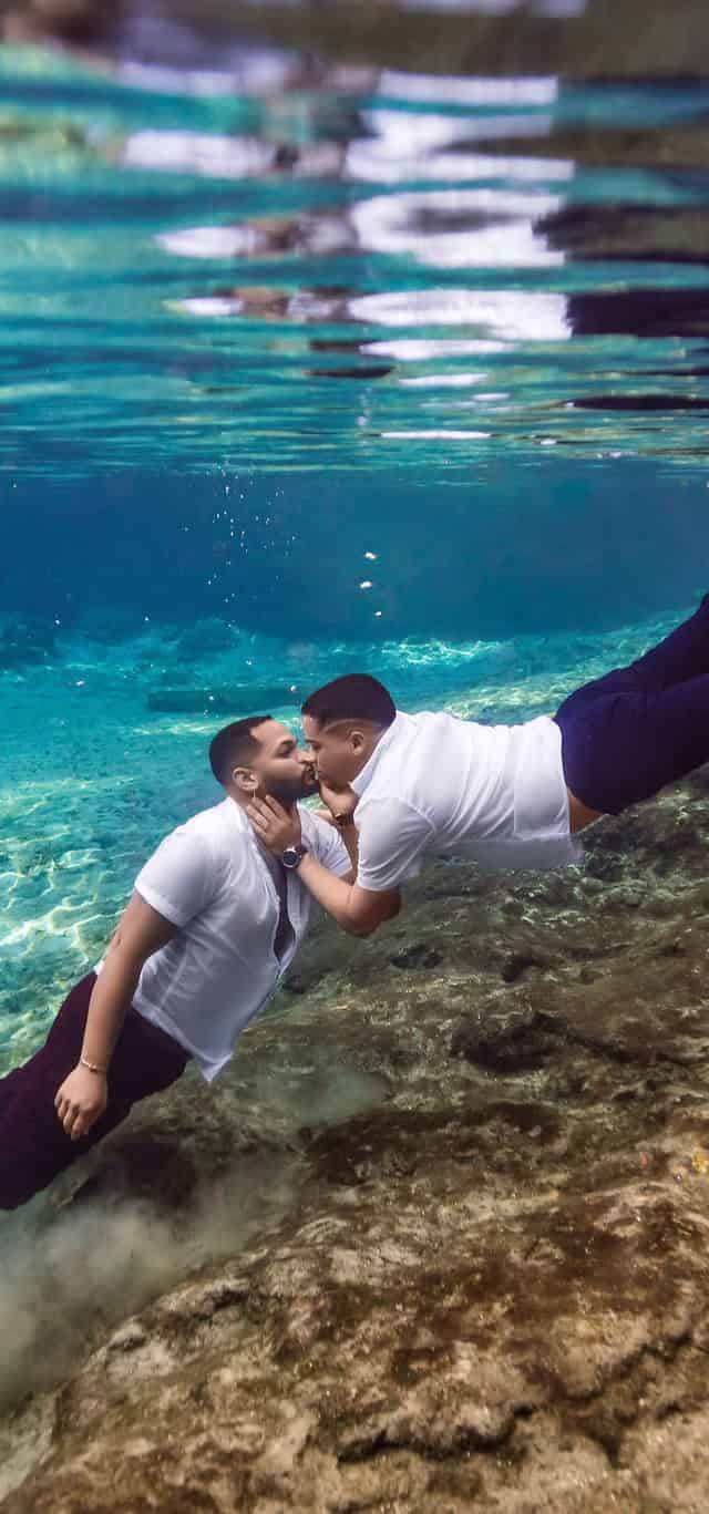 Gay couple kisses underwater during an underwater elopement ceremony at the Florida springs