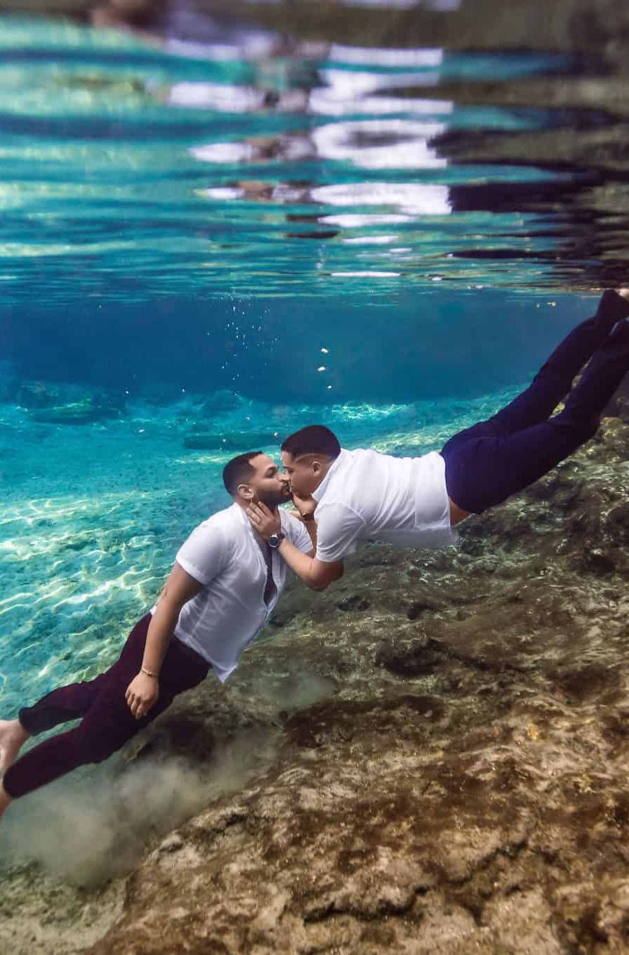Gay couple kisses underwater during an underwater elopement ceremony at the Florida springs