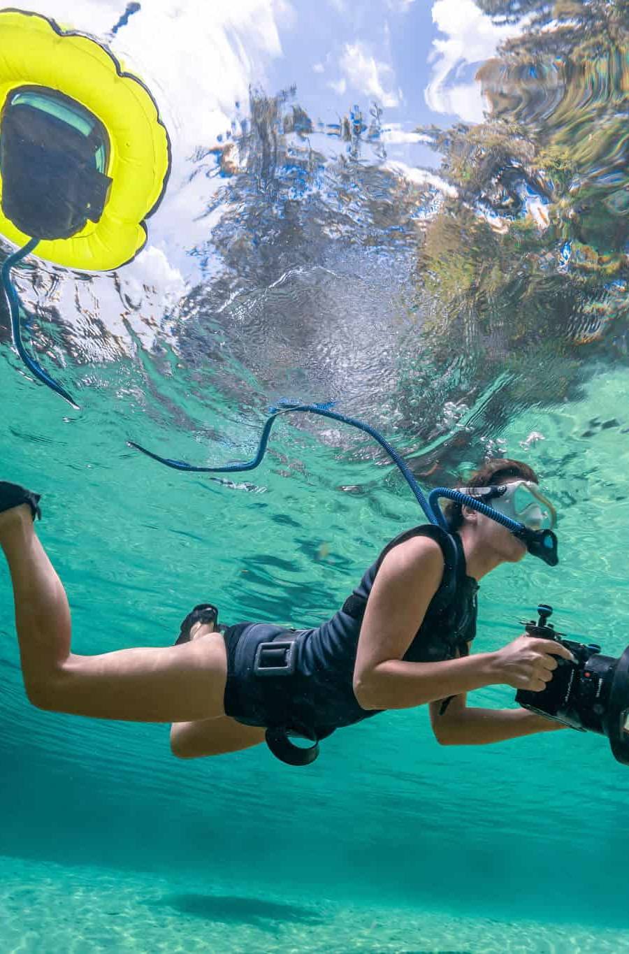 Kimber Greenwood diving underwater with camera gear in crystal clear Florida springs