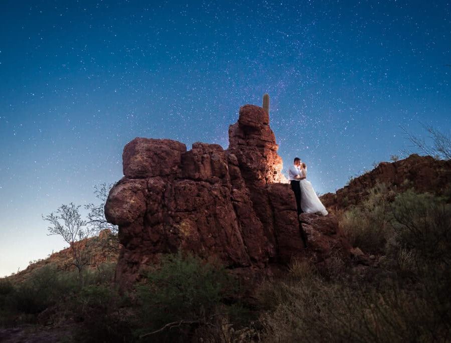 Couple photographed together outdoors under a starry sky for a family announcement