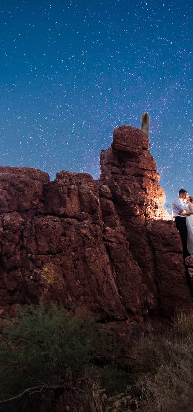 Couple poses on red rocks in Tuscan Arizona during their micro wedding