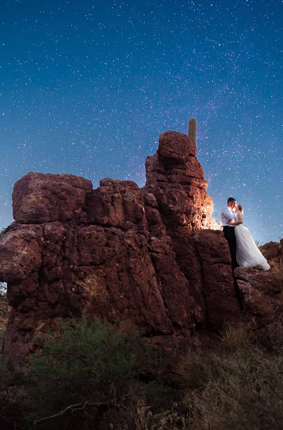 Couple poses on red rocks in Tuscan Arizona during their micro wedding