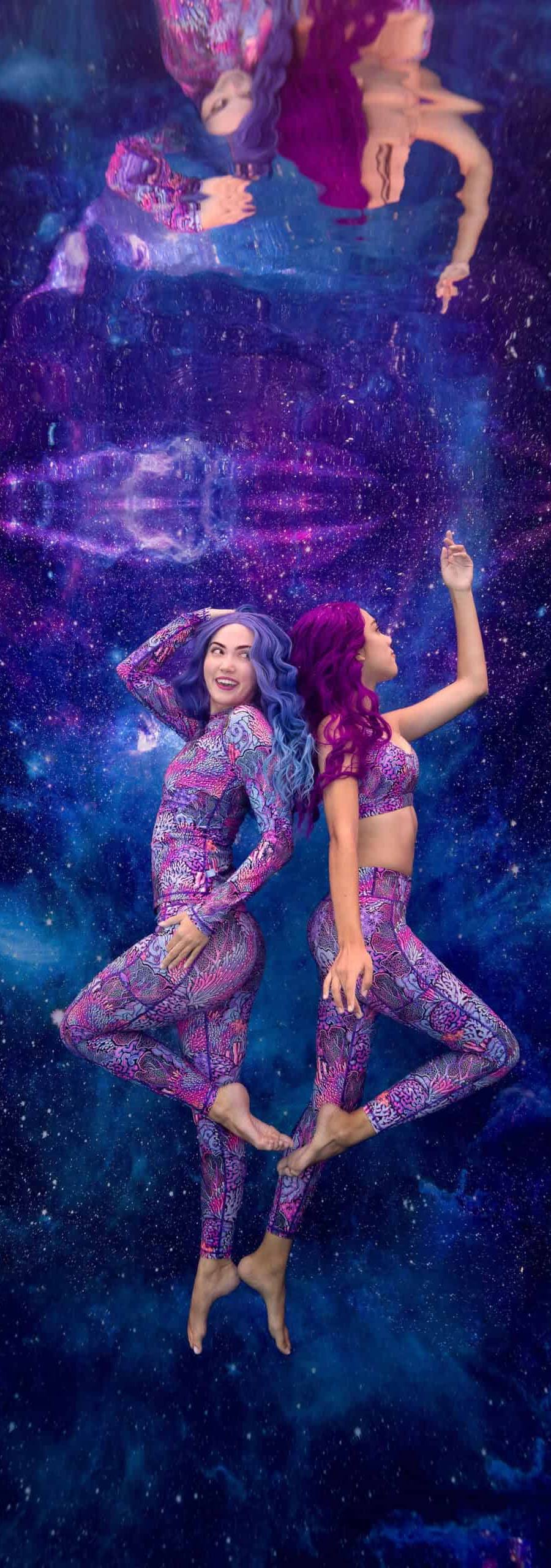 Two models posing underwater against a galaxy backdrop wearing Spacefish Army rashguards and pants.