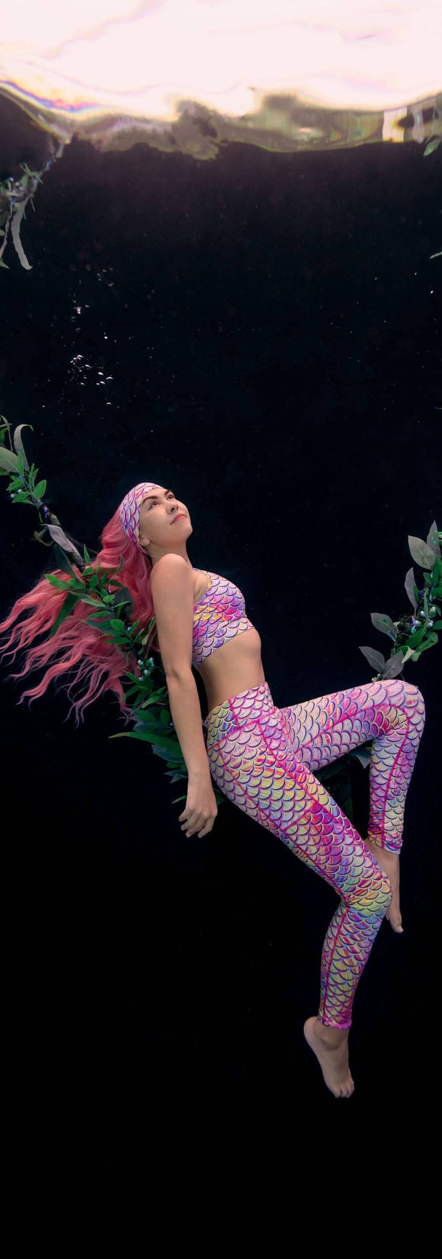 Underwater model lays on kelp strands made into a swing during a pool shoot for Spacefish Army.