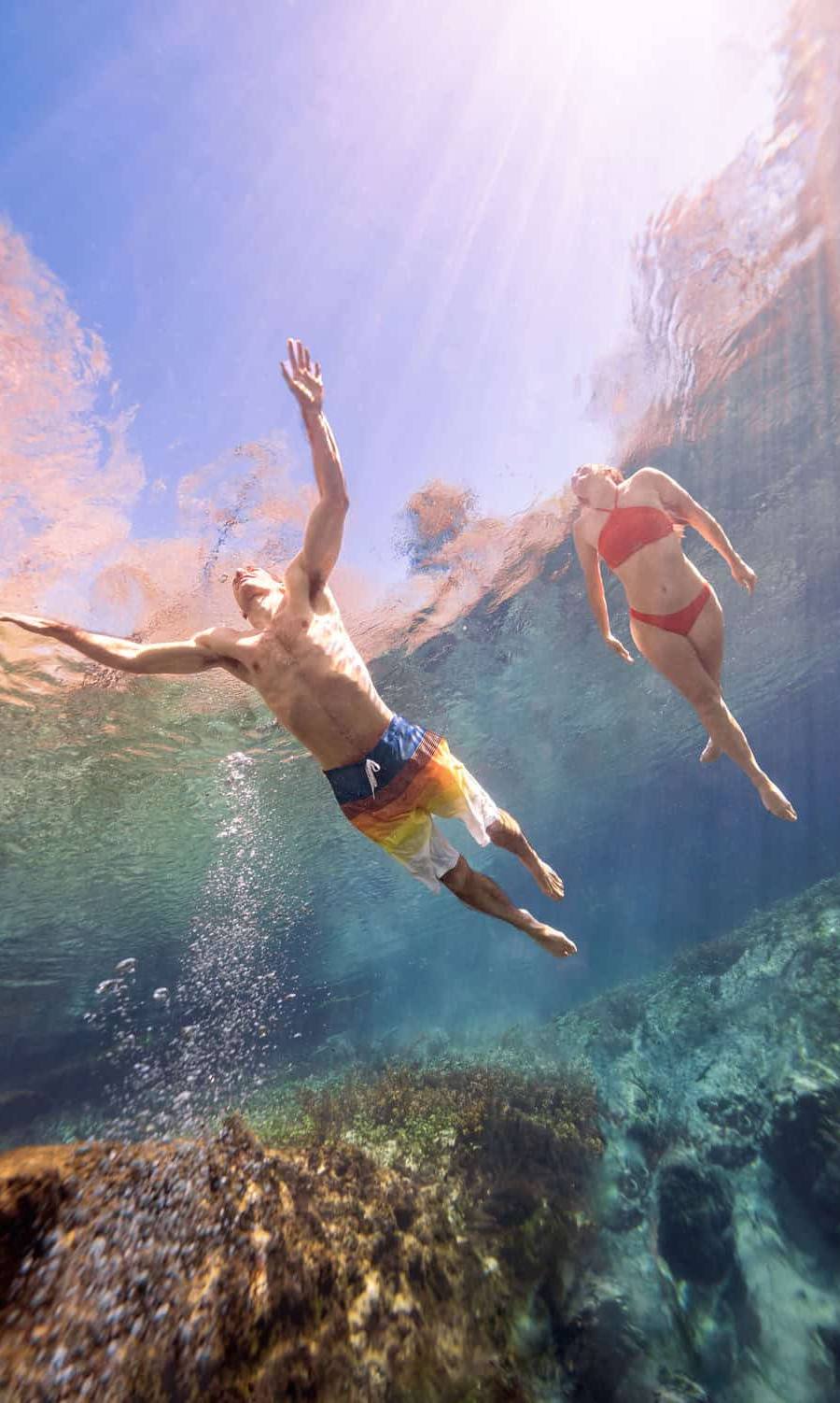 A couple swimming at Ichetucknee Springs State Park, photographed from below.