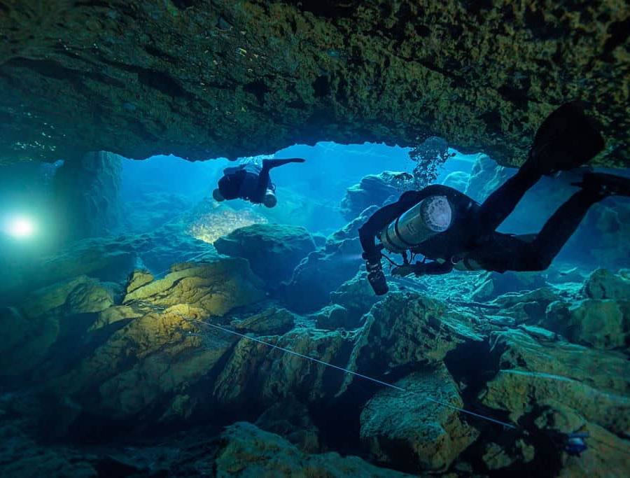 Two cave divers follow a line to the exit of an underwater cave system at Wes Skyles Peacock Springs State Park.