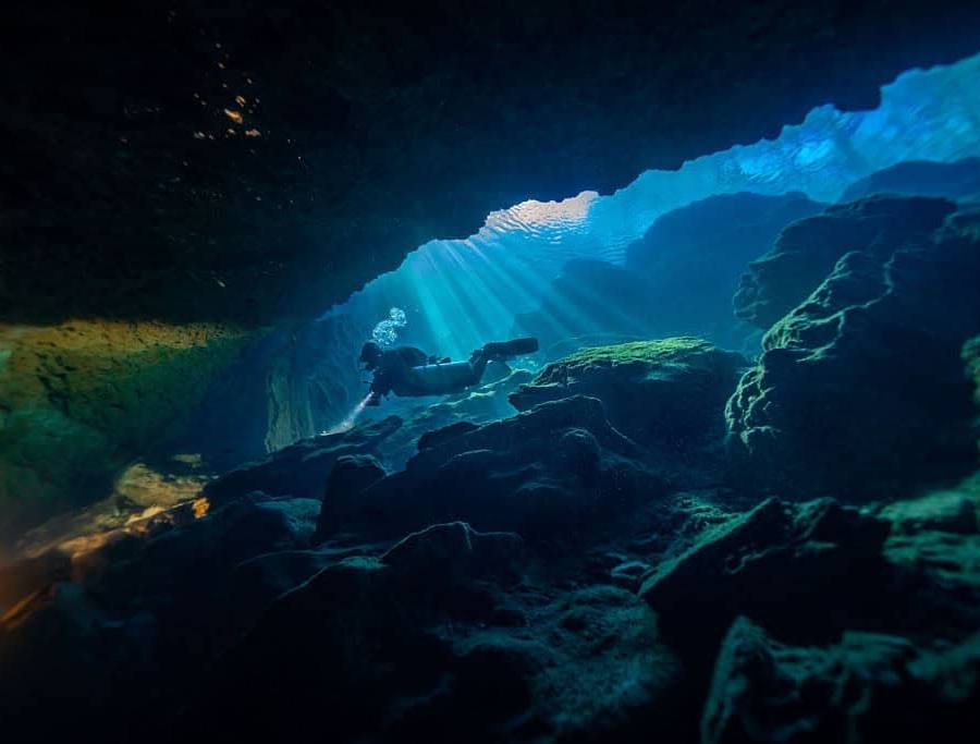 Sidemount cave diver enters the cavern zone of the P1 entrance for the Peacock cave system.