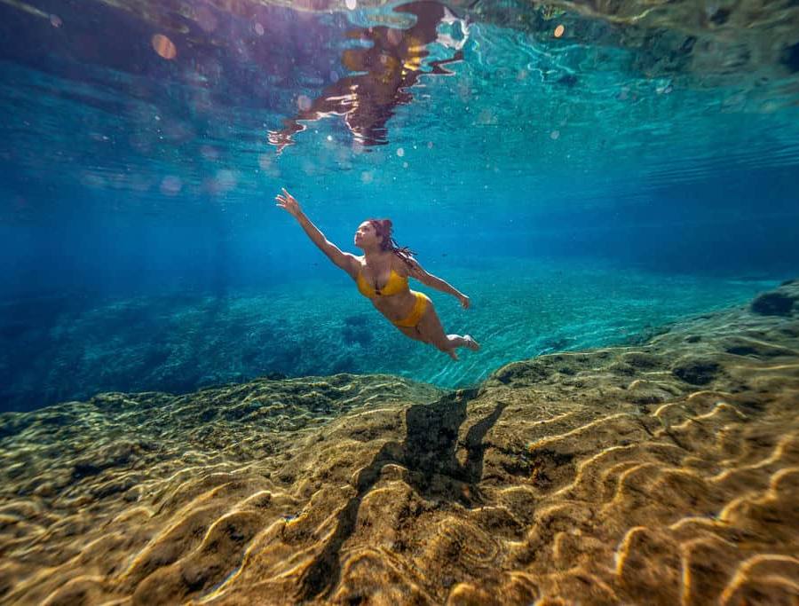 A woman swimming under the water at the basin at Ichetucknee Springs.