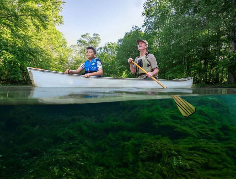 Canoe at Florida Springs with algae covered Spring basin caused by fertilizer input.