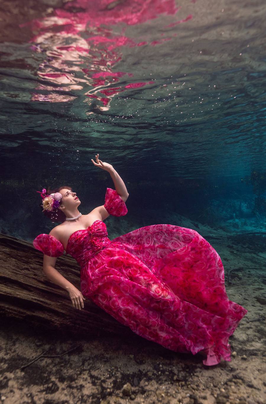 Woman poses underwater in red dress at Florida Spring